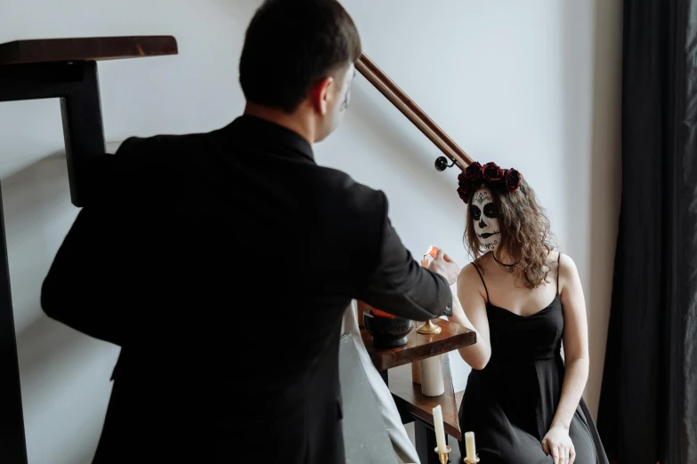 a man standing next to a woman in a black dress, pexels contest winner, gothic art, there is a skull over a table, la catrina, profile image, top down photo