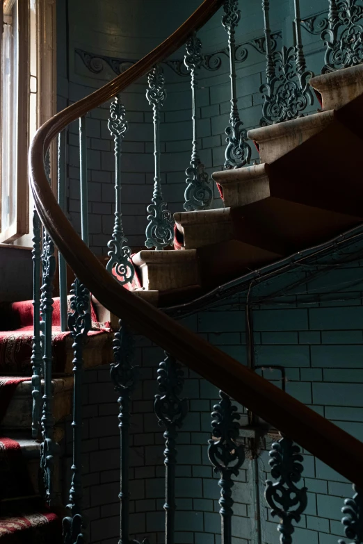 a room with a spiral staircase next to a window, inspired by Louise Bourgeois, art nouveau, dark teal, victorian london, staircases, worn