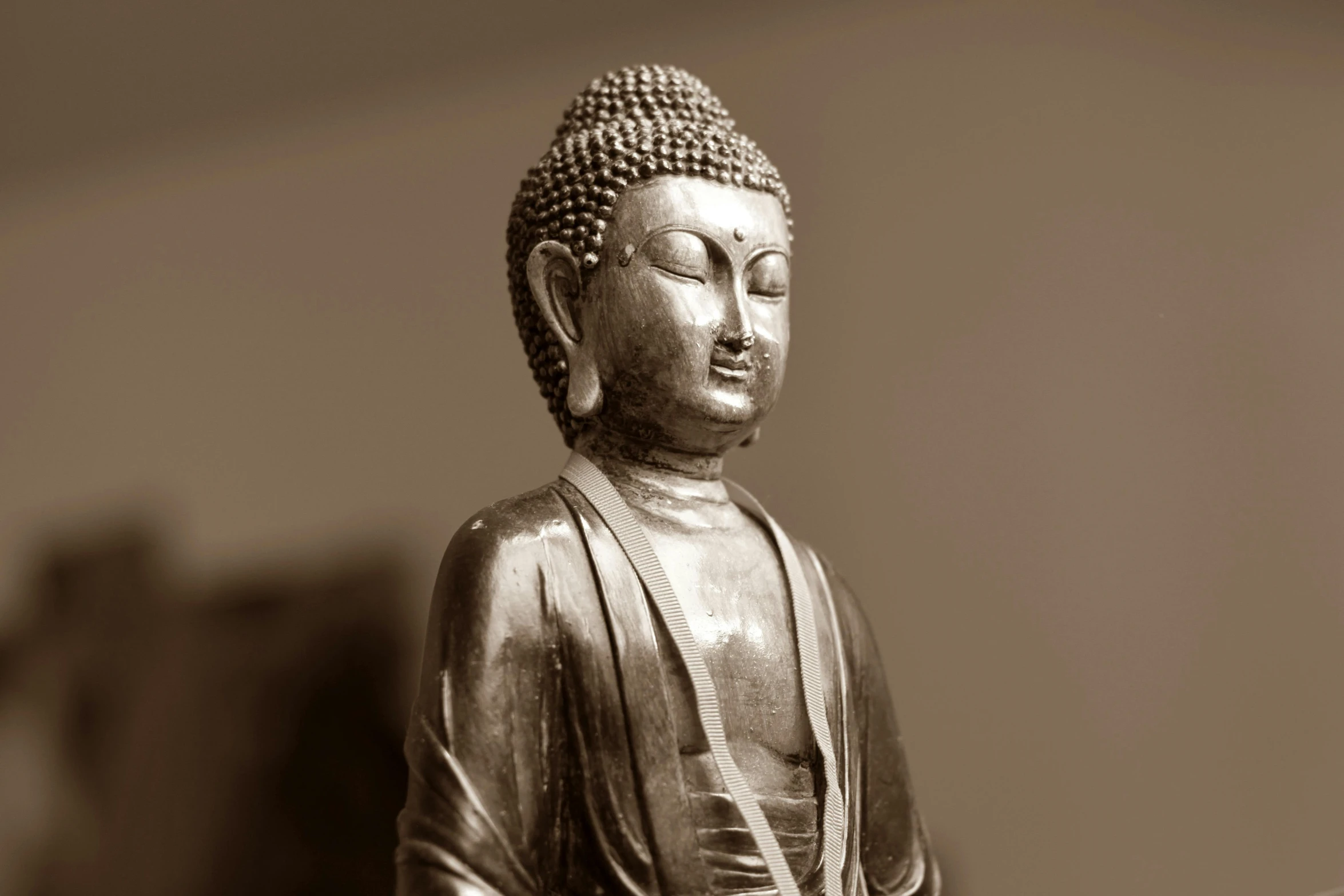 a black and white photo of a buddha statue, a statue, unsplash, cloisonnism, wearing brown robes, as photograph