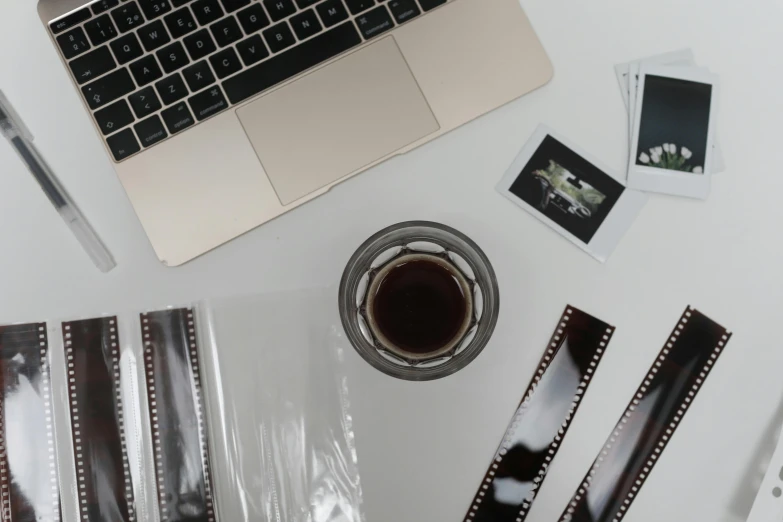 a laptop computer sitting on top of a white desk, a polaroid photo, trending on pexels, video art, film production, used tape, sitting on a mocha-colored table, 3 5 mm film photo