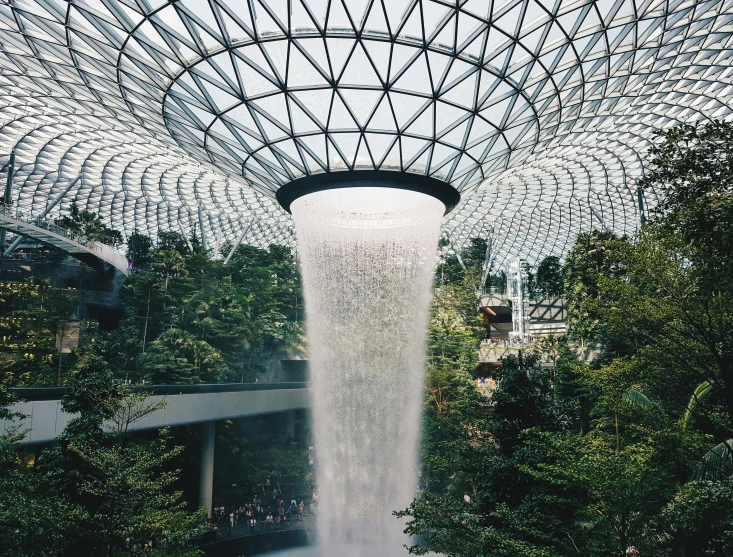 the inside of a building with a waterfall coming out of it, inspired by Cheng Jiasui, pexels contest winner, lush garden spaceship, singapore esplanade, “diamonds, norman foster
