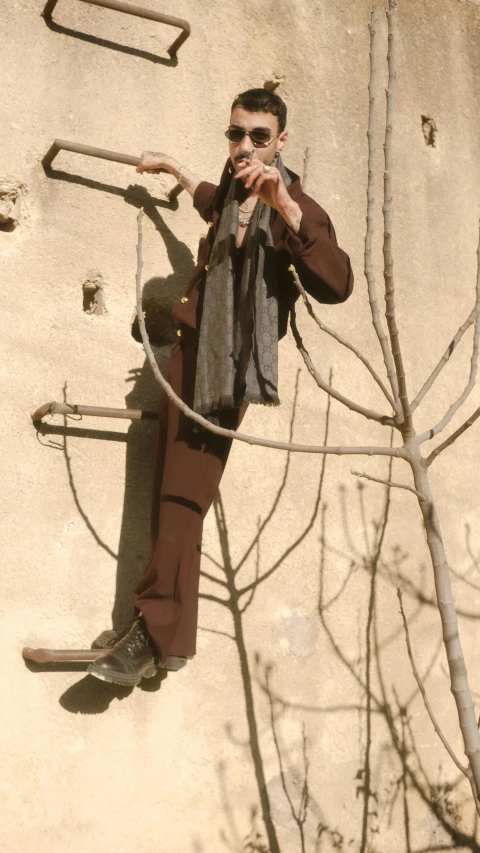 a man hanging on to the side of a building, a statue, inspired by Joseph Beuys, unsplash, taliban, slide show, full body photo, wearing a worn out brown suit