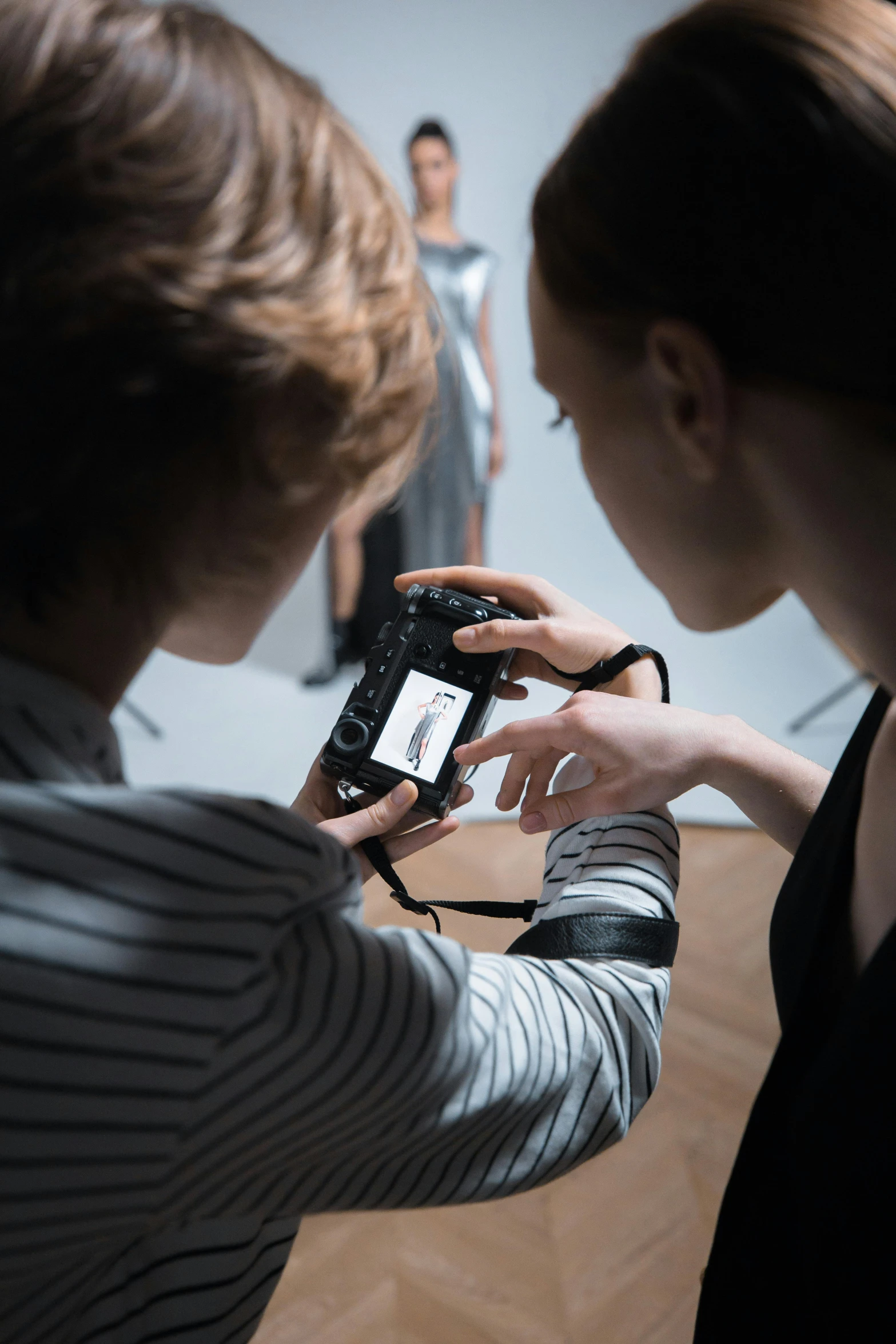 a woman taking a picture of another woman with a camera, by Matthias Stom, trending on unsplash, visual art, close up dslr studio photograph, hasselblad photograph, teaching, at a fashion shoot