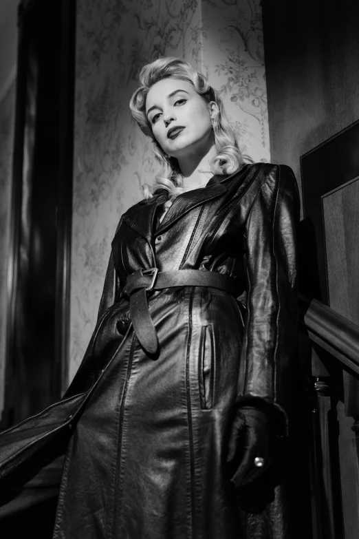 a black and white photo of a woman in a leather coat, inspired by George Hurrell, reddit, photorealism, julia garner, 1950s film noir, digital image, leather clothing