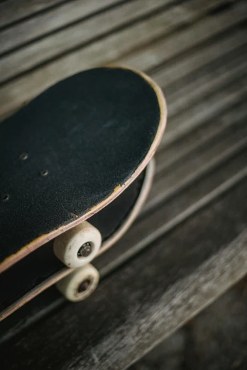 a skateboard sitting on top of a wooden bench, by Dan Christensen, trending on unsplash, bottom body close up, chalk, low quality photo, aged 2 5