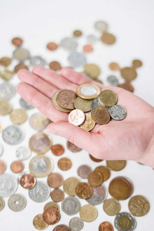 a person holding a handful of coins in their hand, an album cover, by Alison Watt, trending on unsplash, renaissance, 15081959 21121991 01012000 4k, multicoloured, high angle close up shot, tall thin