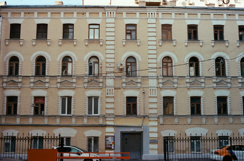 a car is parked in front of a building, inspired by Mikhail Yuryevich Lermontov, pexels contest winner, square, sovietwave aesthetic, brown, 1999 photograph