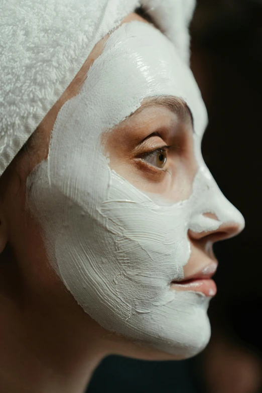 a woman with a towel wrapped around her head, by Adam Marczyński, trending on pexels, renaissance, a plaster on her cheek, white mask, close up of face, square facial structure