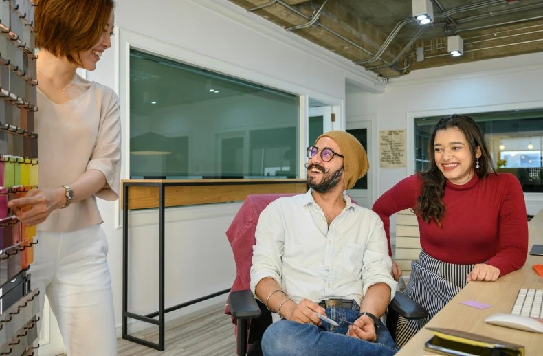 a couple of people that are sitting in a chair, in an office, 9 9 designs, smiling at each other, background image