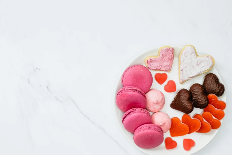 a white plate topped with lots of different types of cookies, a still life, by Nicolette Macnamara, pexels, romanticism, hot pink, cupid, macaron, thumbnail