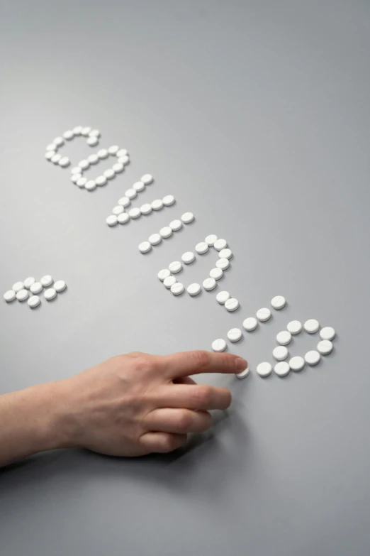 a person's hand reaching for pills on a table, inspired by david rubín, bubble letters, vdovenko, getty images, dezeen