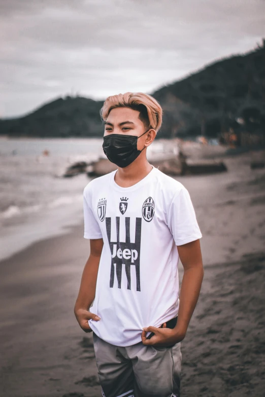 a man standing on a beach wearing a face mask, unsplash contest winner, renaissance, black jersey, discord profile picture, soccer, jpop clothing