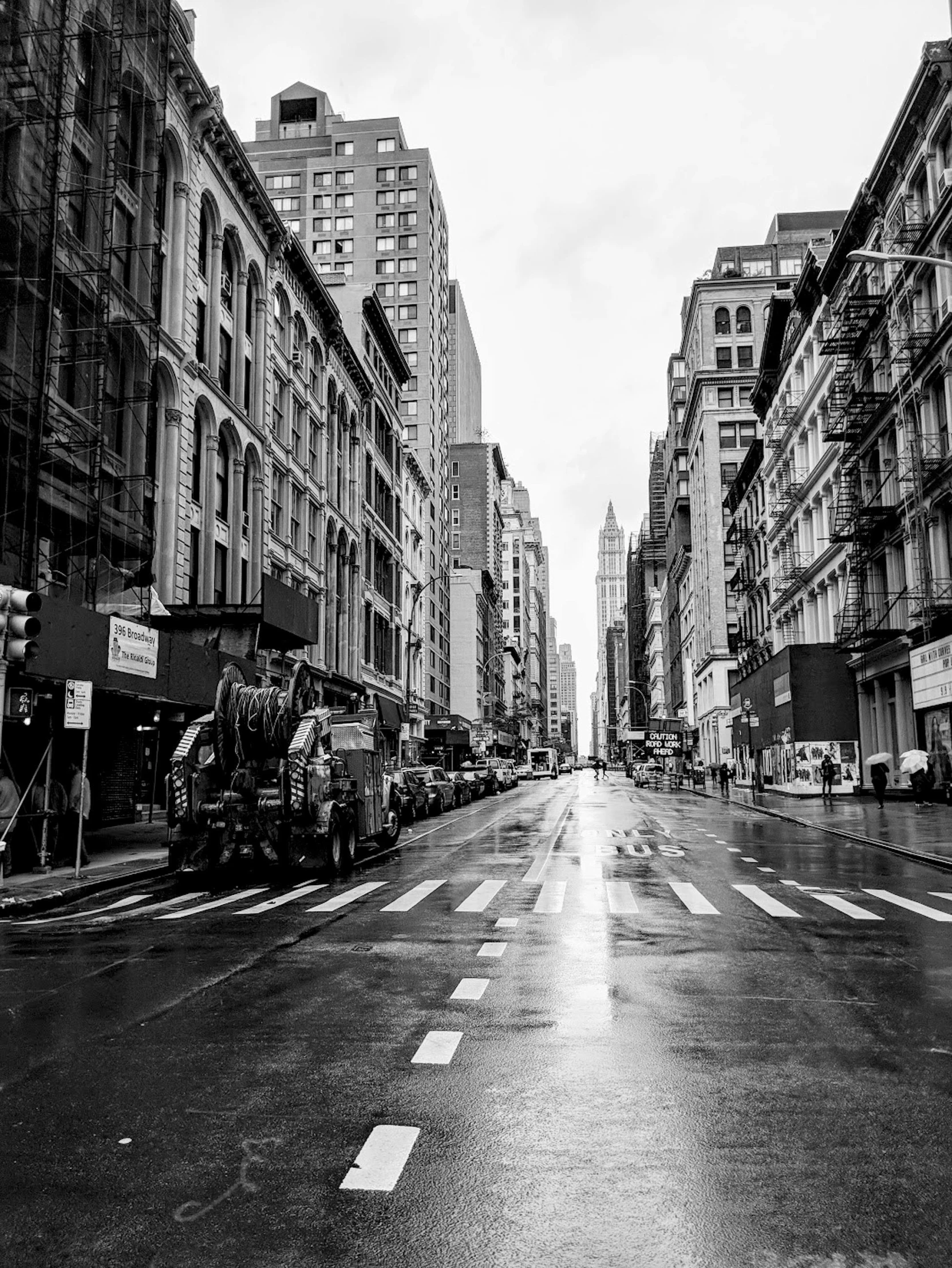 a black and white photo of a city street, by Daniel Gelon, wet aslphalt road after rain, street of new york, it\'s raining, by joseph binder