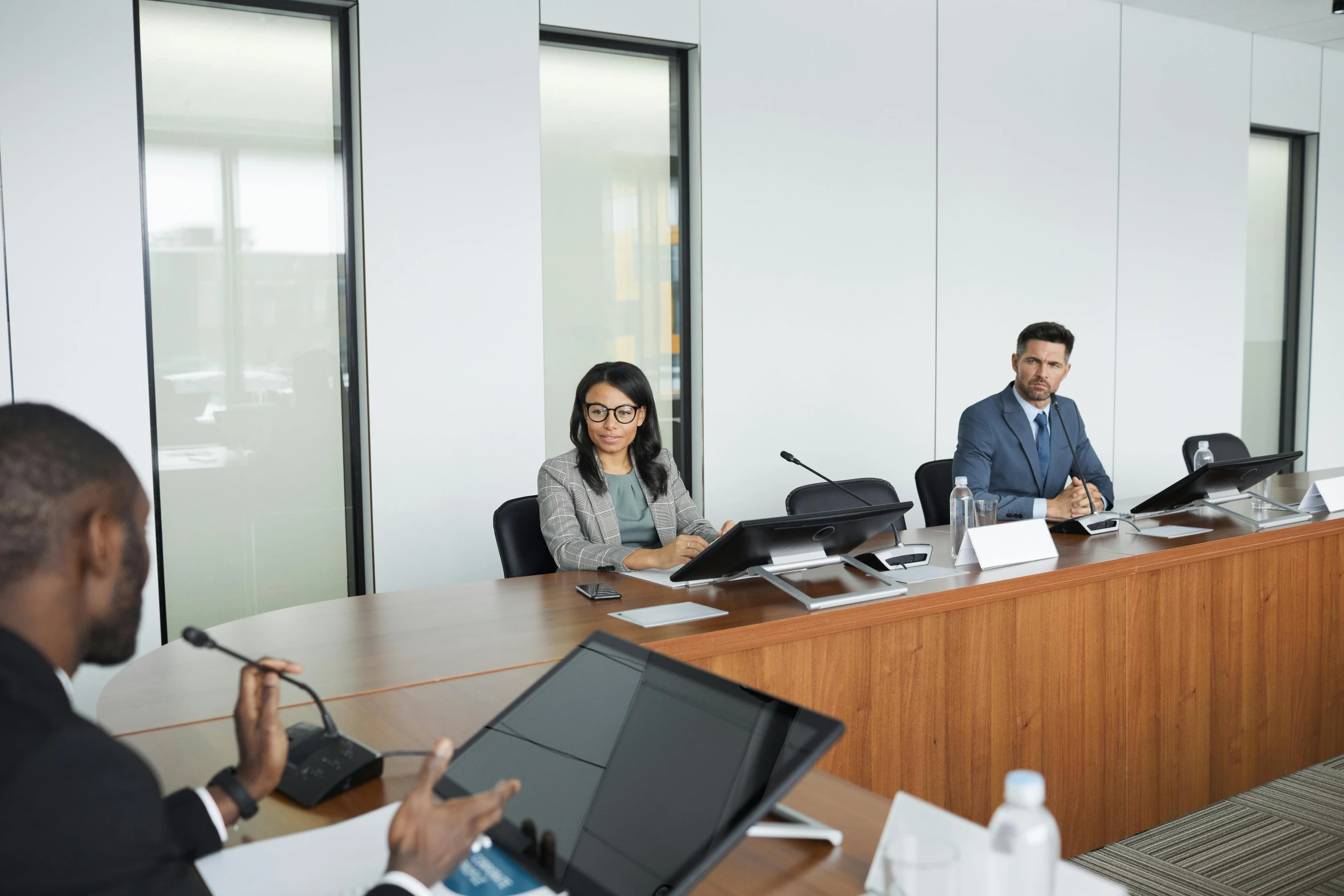 a group of people sitting around a conference table, hurufiyya, realistic »