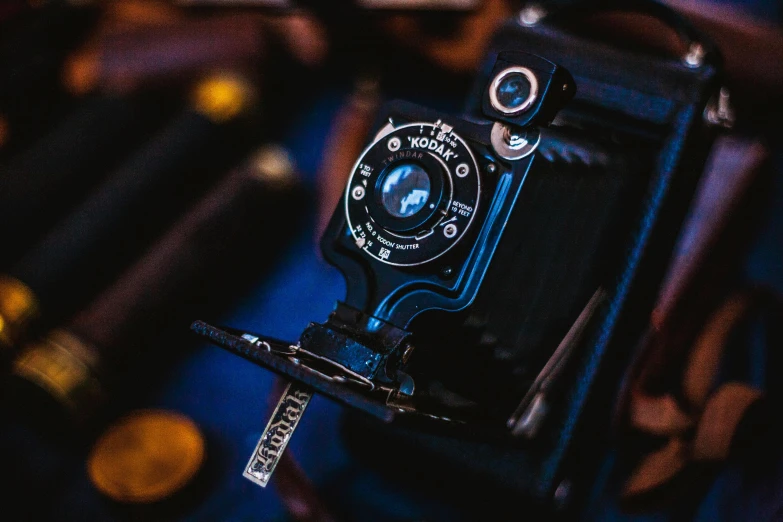 a close up of a camera on a table, by Adam Marczyński, pexels contest winner, 1920s photography, blue, medium format, old timey