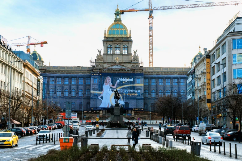 a large building with a statue in front of it, by Tom Wänerstrand, happening, prague in the background, digital billboard in the middle, construction, promo image