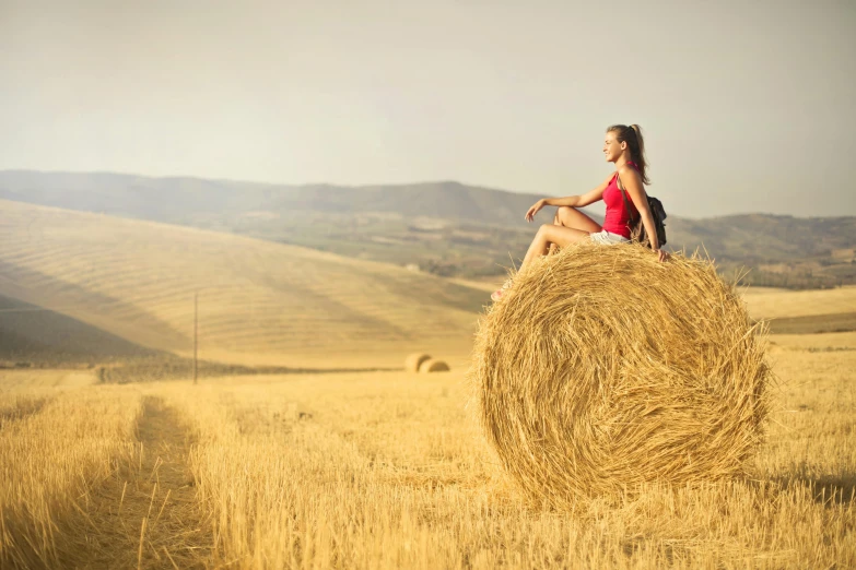 a woman sitting on top of a hay bale, pexels contest winner, renaissance, tuscany hills, post processed, stubble, peaceful scene