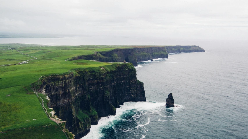 a large body of water next to a cliff, pexels contest winner, irish genes, 🚿🗝📝