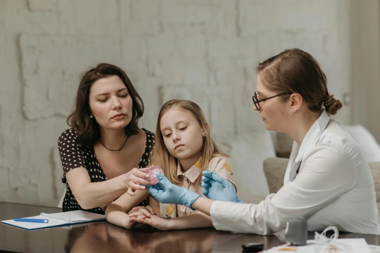 a woman sitting at a table with a little girl, bandages, medical lab, gen z, partially cupping her hands