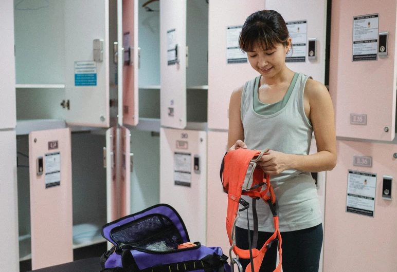 a woman standing next to a luggage bag, pexels contest winner, chun li at the gym, belaying, worksafe. instagram photo, pink body harness