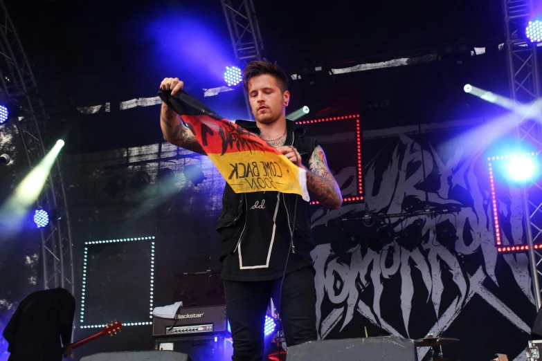 a man holding a sign on top of a stage, a tattoo, hurufiyya, venomize, slightly smirking, avatar image, adrian borda