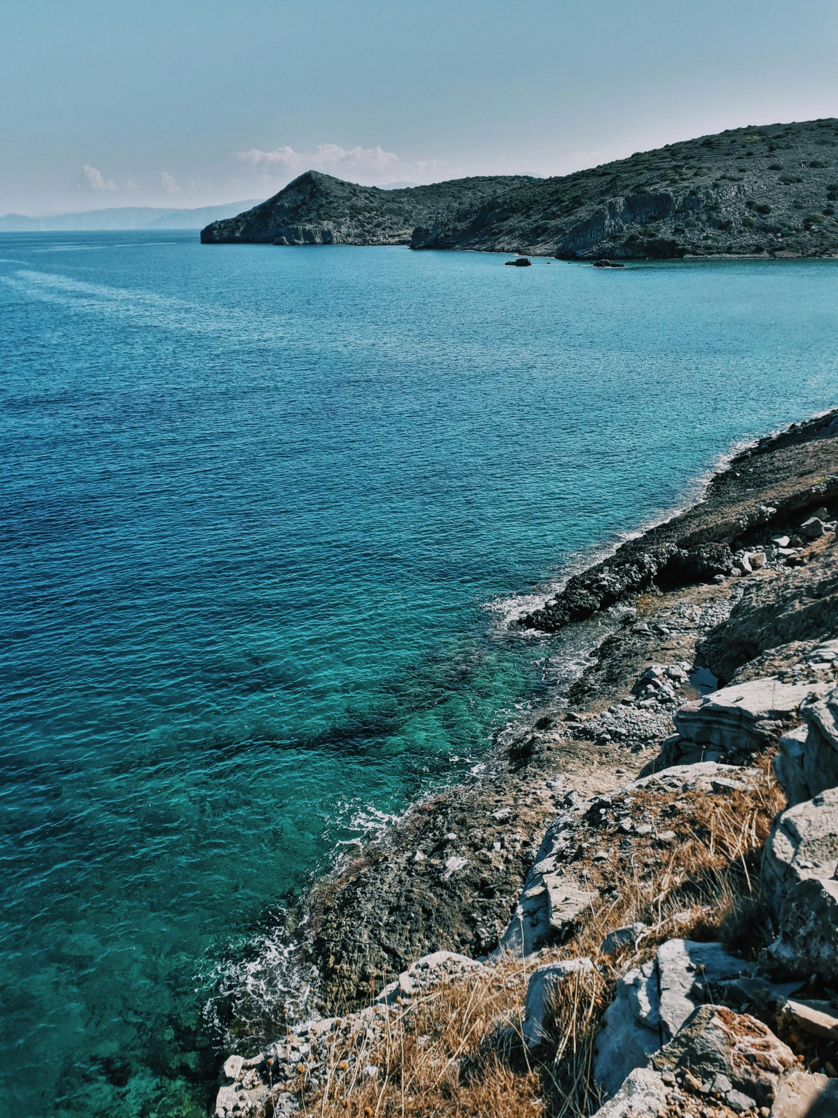 a large body of water next to a rocky shore, by Alexis Grimou, pexels contest winner, greek nose, shades of blue and grey, slide show, thumbnail