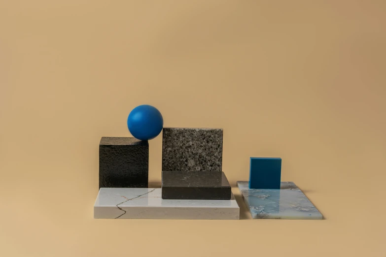 a blue ball sitting on top of a marble block, an abstract sculpture, inspired by Bauhaus, suprematism, material pack, rectangle, black and blue, vinyl material