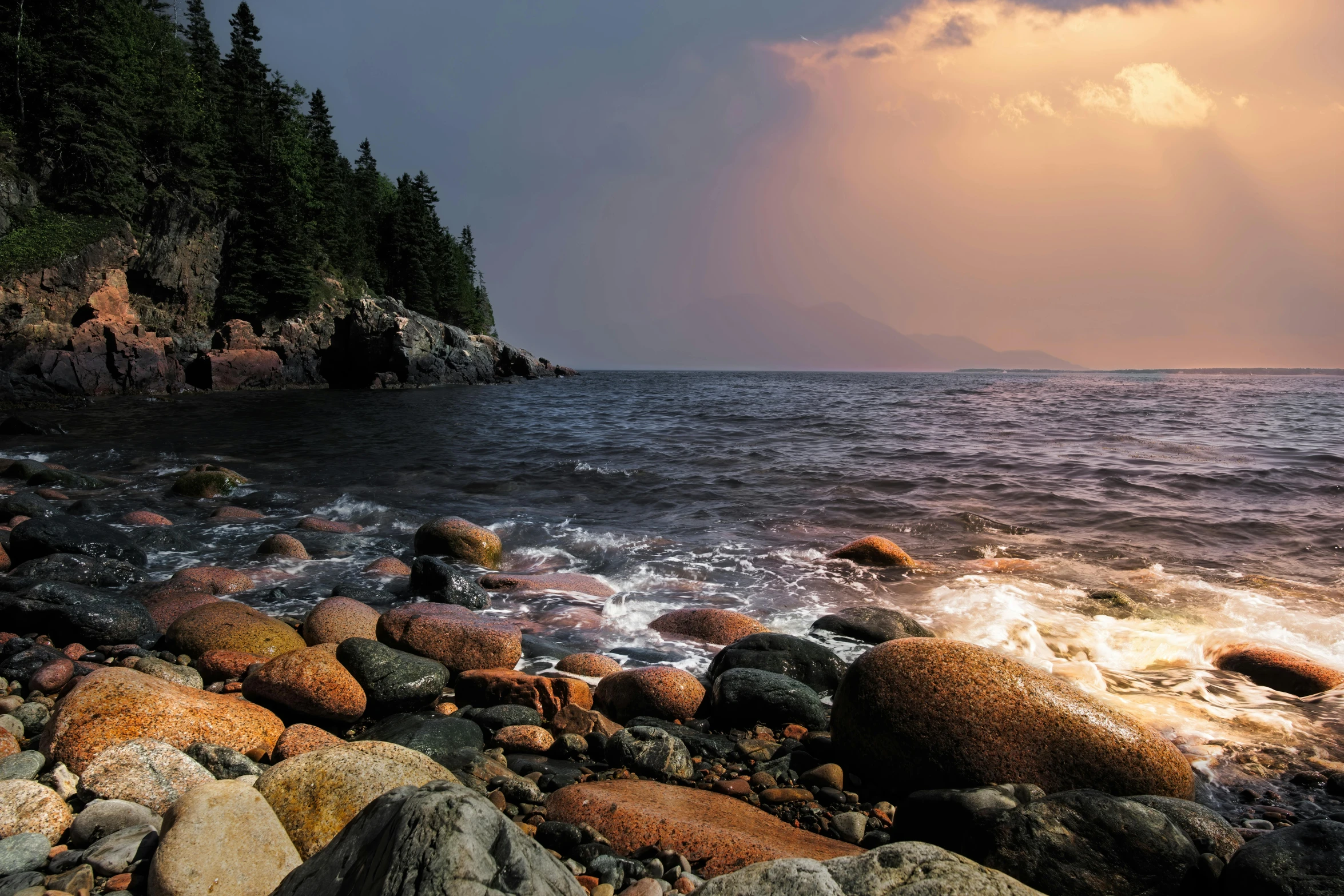 a large body of water surrounded by rocks and trees, unsplash contest winner, hudson river school, evening storm, seaside, tourist photo, a colorful