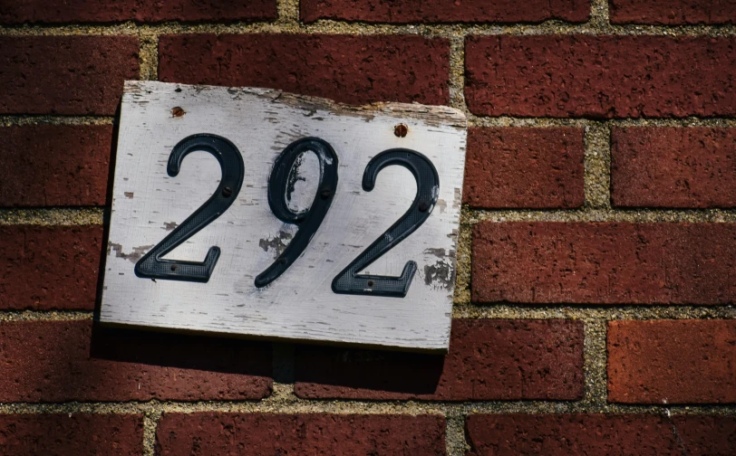 a close up of a sign on a brick wall, 2029, house, 2b, 2 b