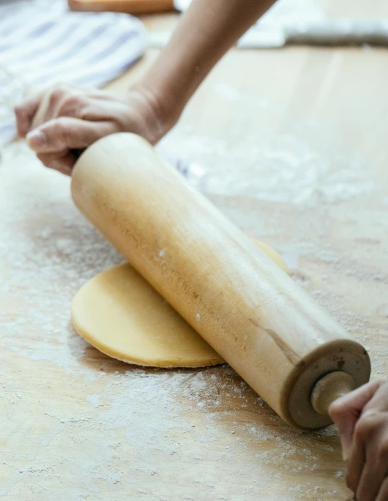 a person rolling out dough on a table, inspired by Sarah Lucas, unsplash, made of bamboo, square, best chef, wavy