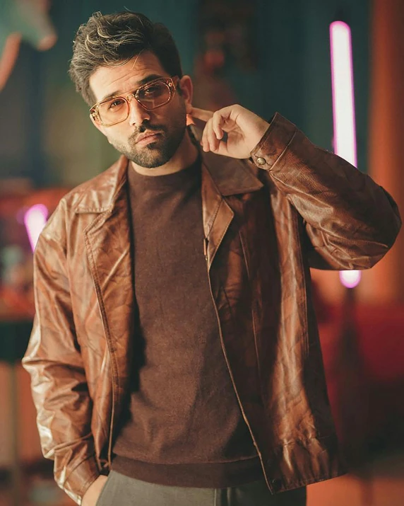 a man wearing a brown jacket and glasses, trending on pexels, hurufiyya, zachary quinto, vintage color, model posing, wearing leather