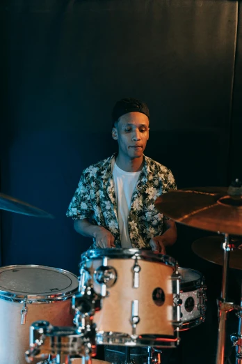 a man sitting in front of a drum set, by Robbie Trevino, riyahd cassiem, gif, slightly smiling, studio picture