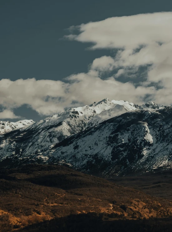 a snow covered mountain range under a cloudy sky, unsplash contest winner, slightly tanned, trending on vsco, low quality footage, portrait photo