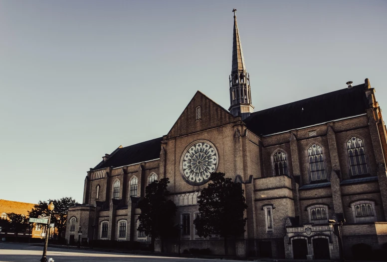 a church with a clock on the front of it, a photo, unsplash, romanesque, sunfaded, chrome cathedrals, gray, from wheaton illinois