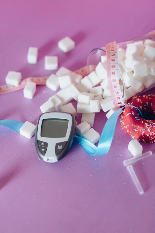 a pink table topped with a donut covered in sugar, by Julia Pishtar, pexels, happening, medical labels, monitor, square, 2000s photo