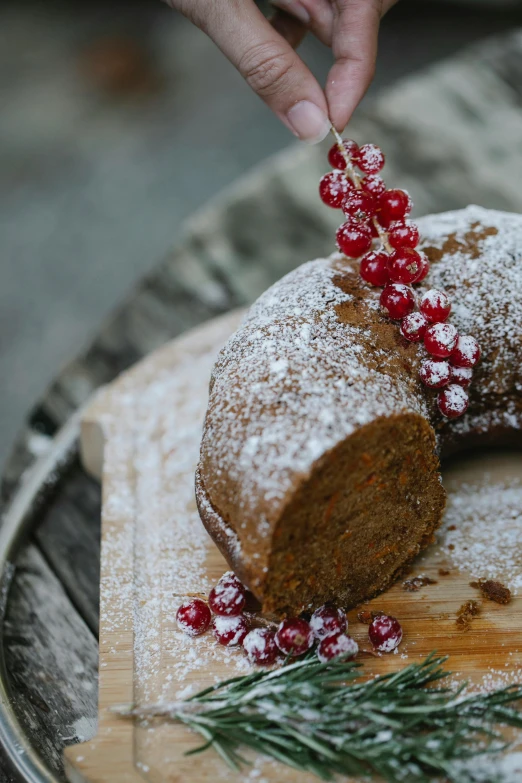 a piece of cake sitting on top of a wooden cutting board, by Haukur Halldórsson, festive atmosphere, bun ), bittersweet, feature