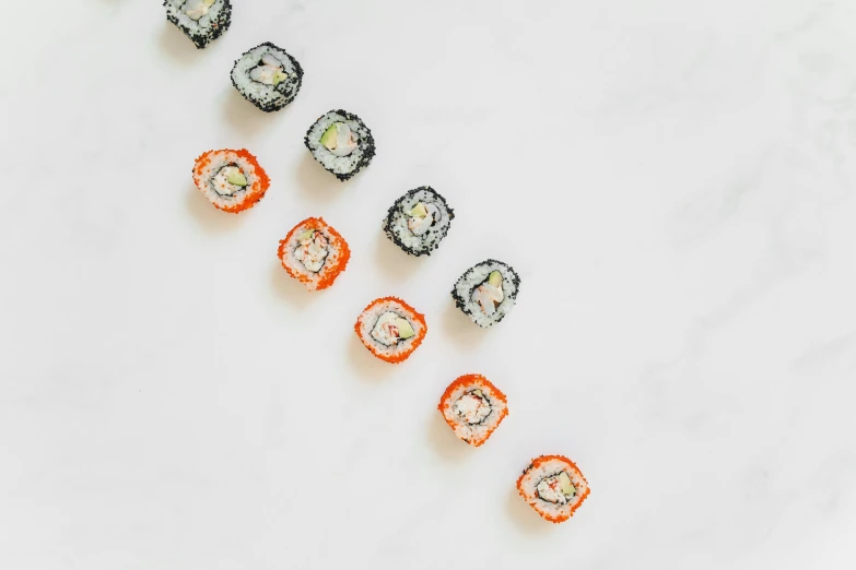 a number of sushi rolls on a white surface, inspired by Maki Haku, trending on pexels, gray and orange colours, gems, eight eight eight, 6 pack