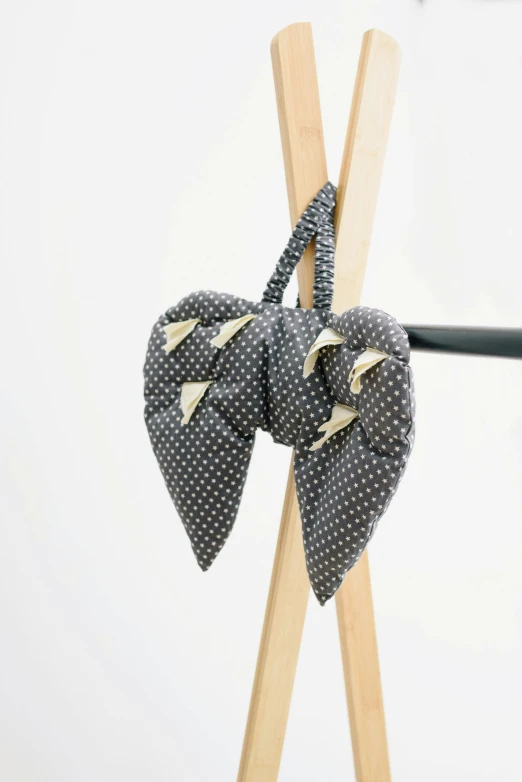 a pair of skis with a bow tied to them, by Ruth Simpson, visual art, polka dot, grey cloth, close-up product photo, large leaves