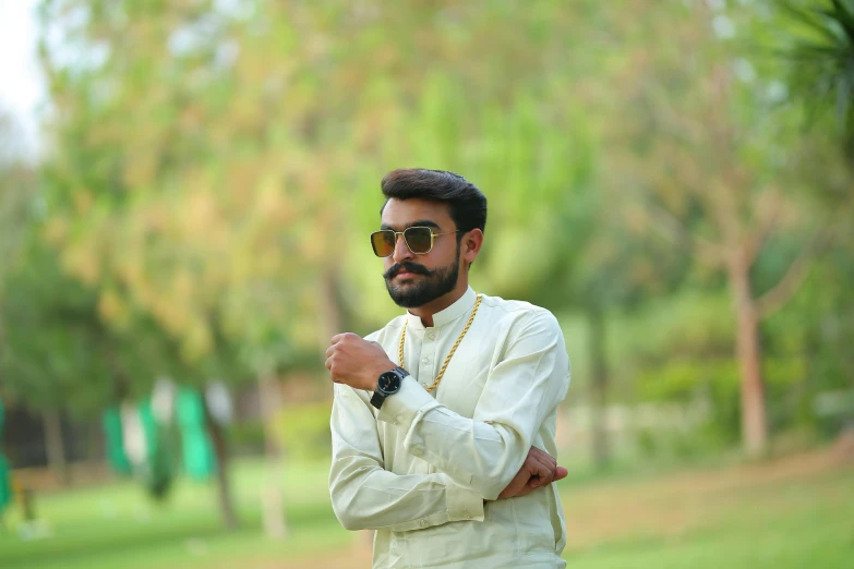 a man that is standing in the grass, by Manjit Bawa, pexels contest winner, hurufiyya, elegant glamor pose, avatar image, green shades, wearing white clothes