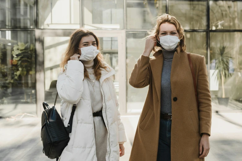 a couple of women standing next to each other, trending on pexels, happening, dust mask, anthro, cold weather, healthcare