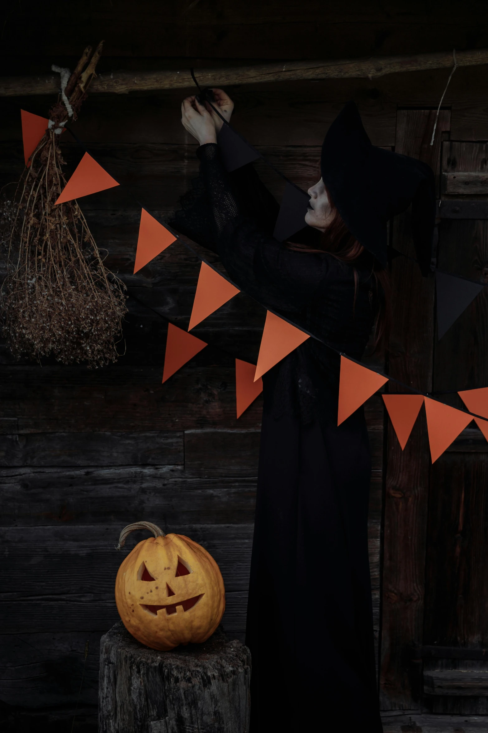 a woman dressed as a witch standing next to a pumpkin, trending on pexels, conceptual art, red pennants, dark. no text, blank, hanging