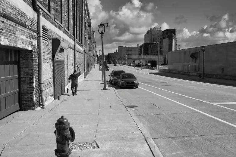 a black and white photo of a fire hydrant, a black and white photo, inspired by Vivian Maier, pexels contest winner, photorealism, cars on the road, cleveland, people walking around, behind the scenes photo