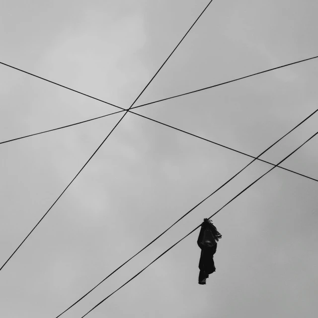 a pair of shoes hanging from power lines, a black and white photo, by Jan Rustem, pexels contest winner, postminimalism, obscured hooded person walking, cables on her body, square lines, a pilgrim