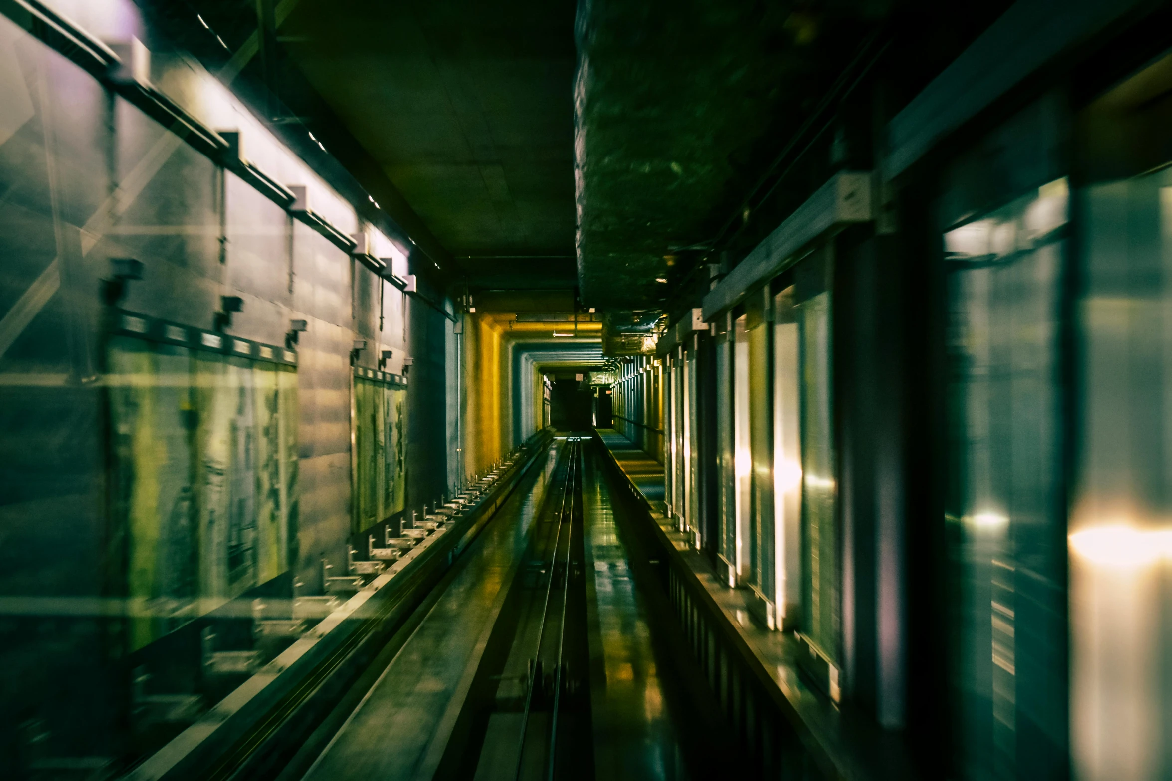 a train traveling down a train track next to a tunnel, inspired by Elsa Bleda, unsplash contest winner, bauhaus, in an elevator, medium format film photography, cyberpunk streets in japan, 2000s photo