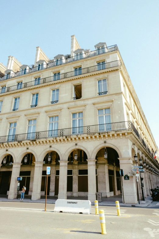 a tall building sitting on the corner of a street, unsplash, paris school, on a great neoclassical square, storefront, ivory, voluminous