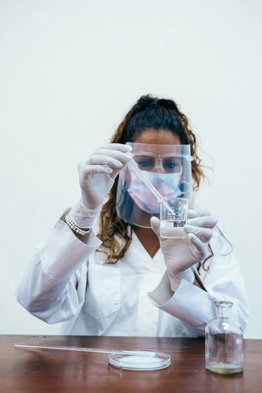 a woman in a lab coat holding a test tube, by Adam Marczyński, pexels contest winner, wearing transparent glass mask, gif, 30-year-old woman from cuba, resin