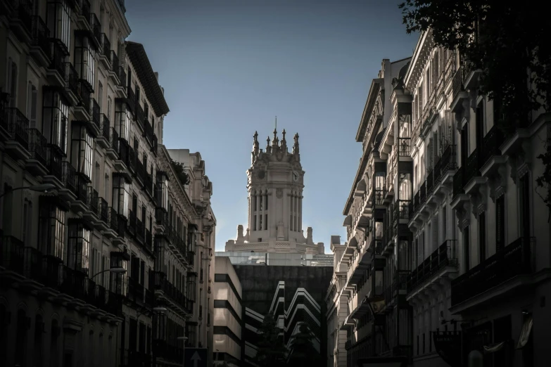a very tall clock tower towering over a city street, inspired by Josep Rovira Soler, unsplash contest winner, neoclassicism, madrid, square, gargoyles, high resolution image