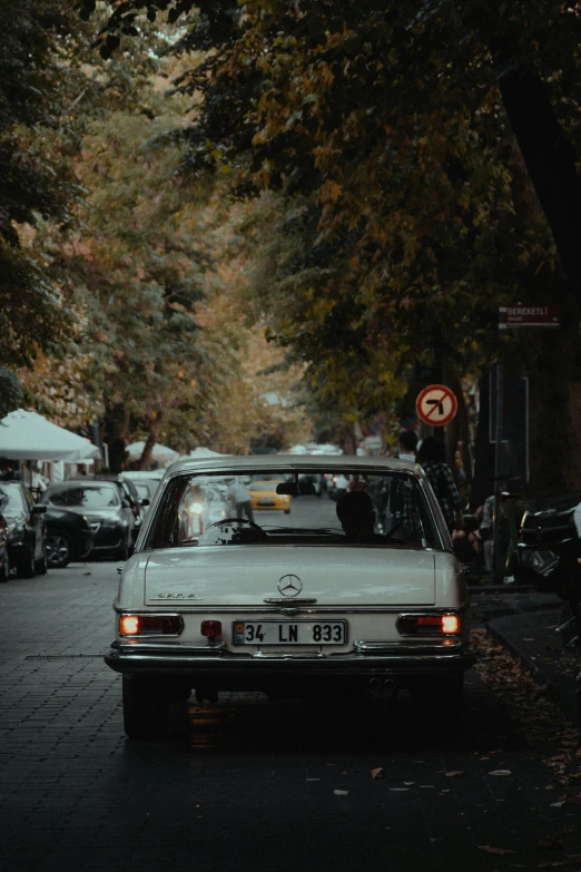 a white car parked on the side of a road, pexels contest winner, happening, kreuzberg, autumn lights, vintage cars, square