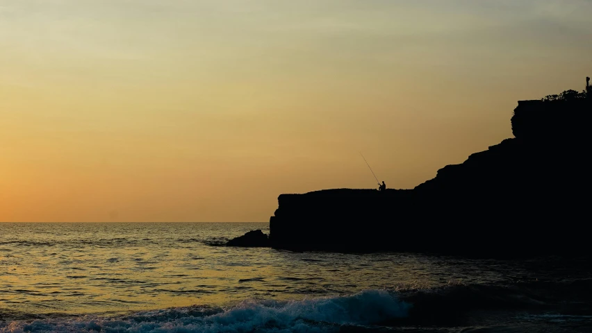 a man flying a kite on top of a sandy beach, pexels contest winner, minimalism, cliff side at dusk, fishing, marsden, silhouetted