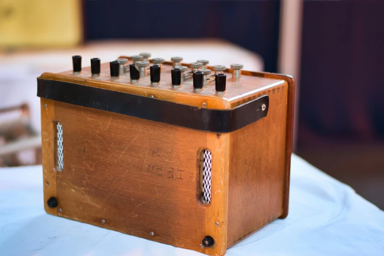 a wooden box sitting on top of a table, synthesizer, instrument, up close, on display